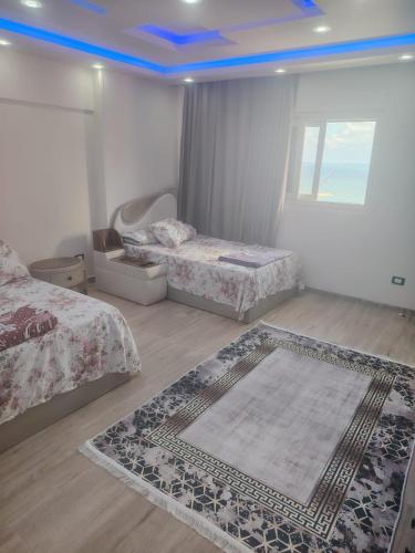 a bedroom with two beds and a blue ceiling at Apartment with panoramic sea view sidi bshr Families only in Alexandria