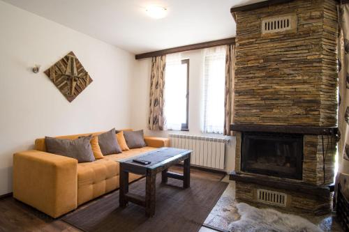 a living room with a couch and a fireplace at Borche Family Homes in Pamporovo