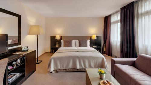 a hotel room with a bed and a couch at Morosani Schweizerhof in Davos