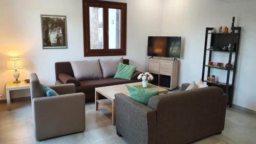 a living room with a couch and a table at Sea view Goldins house in Pteleós