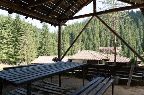 a picnic table in a pavilion with a view of trees at Borche Family Homes in Pamporovo
