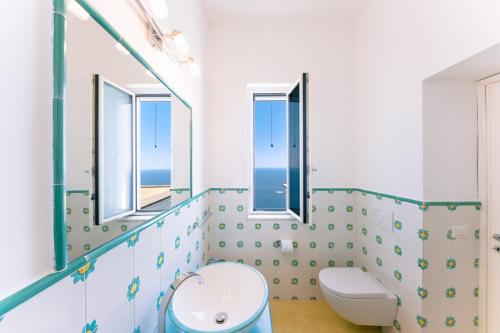 a bathroom with a toilet and a sink at Smeraldo Holiday House in Conca dei Marini