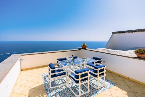 a table and chairs on a balcony with the ocean at Smeraldo Holiday House in Conca dei Marini