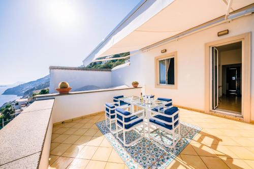 a room with a table and chairs on a balcony at Smeraldo Holiday House in Conca dei Marini