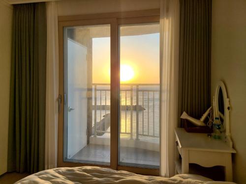 ヤンヤンにあるOcean Stay Yangyangのベッドルーム1室(バルコニーの景色を望む窓付)