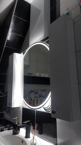 a bathroom with a mirror and a sink at Mansarda Apartman Diva in Prijedor