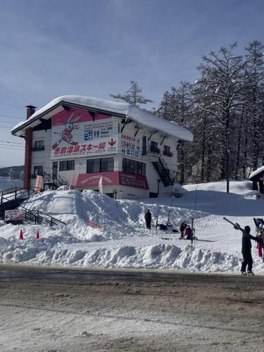 Un edificio con un montículo de nieve delante. en Adamo Akakura, en Myoko