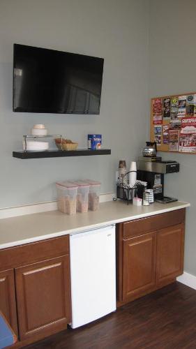 a kitchen with a counter top with a tv on the wall at Wellington Inn in Bracebridge
