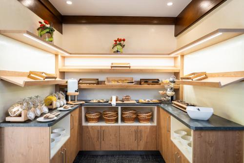 a large kitchen with wooden cabinets and counters at Schi- und Wanderhotel Berghof in Bad Kleinkirchheim