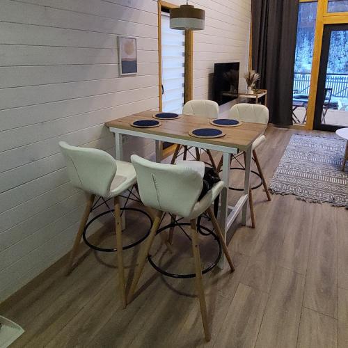 a dining room table with white chairs and a table at White Scandinavian Barn House in Artavaz