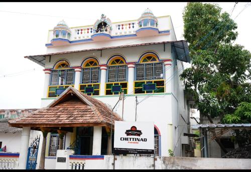 a large white building with a sign in front of it at Chettinad Paradise in Kānādukāttān