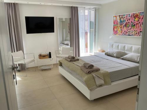 a white bedroom with a bed and a window at Affitta camere Locarno in Minusio