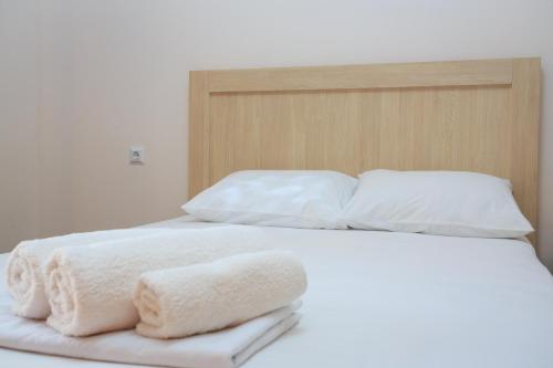a bed with white sheets and pillows on it at Guest House 99 in Batumi