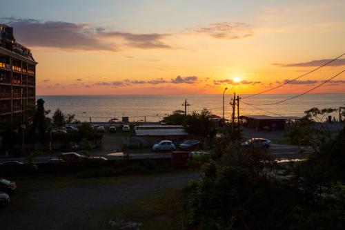 a sunset over the ocean with a parking lot at Guest House 99 in Batumi
