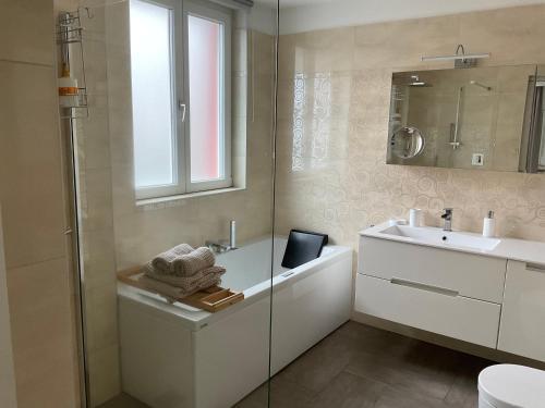 a bathroom with a tub and a sink and a mirror at Affitta camere Locarno in Minusio