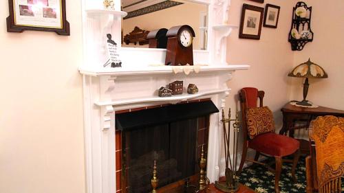 a living room with a fireplace with a clock on top at Saltwood House in Cape May
