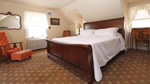 a bedroom with a large bed and a chair at Saltwood House in Cape May