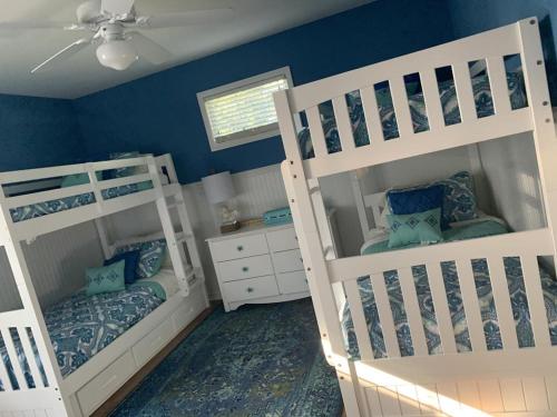two bunk beds in a room with blue walls at Oceanside Brant Beach Single Family Beach Badges Private Yard Wifi Ocean And Bay Views Washer & Dryer This Home Will Allow You To Truly Feel in Brant Beach
