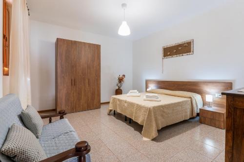 a bedroom with a bed and a table and a couch at Da Zia Vittoria - Affitti Brevi Italia in Ulassai