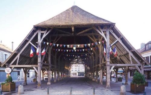 a large wooden bridge with flags on it at Escale19 in Milly-la-Forêt