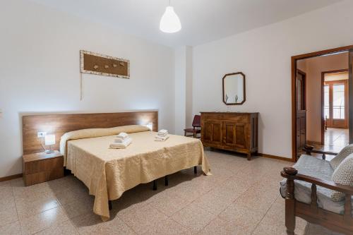 a bedroom with a bed and a table and a mirror at Da Zia Vittoria - Affitti Brevi Italia in Ulassai