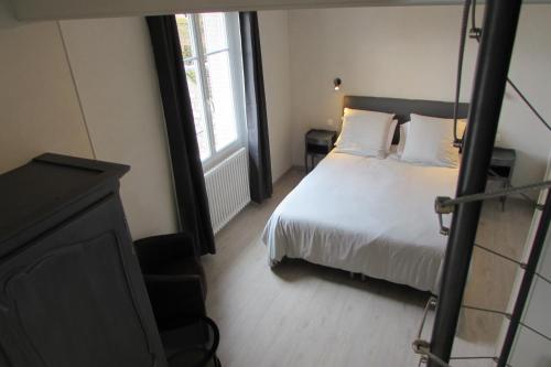 a bedroom with a bed and a chair and a window at Escale19 in Milly-la-Forêt