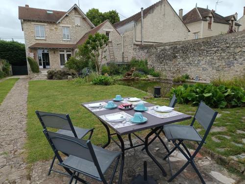 a table and chairs in the yard of a house at Escale19 in Milly-la-Forêt