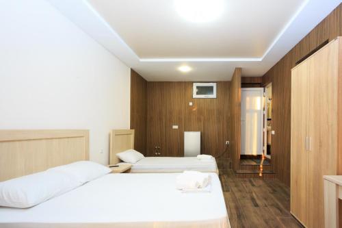 a hotel room with two beds and wooden walls at Guest House 99 in Batumi