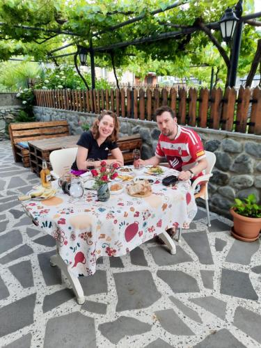 a man and a woman sitting at a table at Guest House Gardenia & Wine Cellar in Lagodekhi
