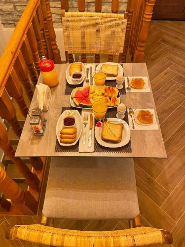 a table with plates of breakfast foods on it at Zilfe Guesthouse in Gjirokastër