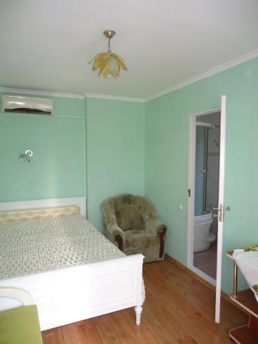 a bedroom with a bed and a chair at Гостевой дом у моря in Odesa