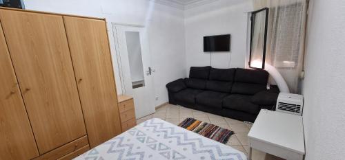 a small living room with a couch and a bed at Nathally room's Gandía in Gandía