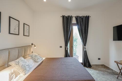 a bed in a room with a couch and a window at Tenuta Poggio Piero in Montemassi