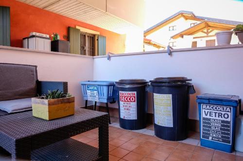 a patio with three trash cans and a bench at Casa vacanza Simona in Salionze