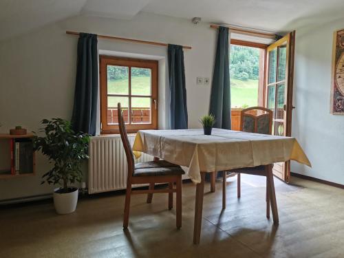 a dining room with a table and chairs and windows at Haus Maria in Campolasta