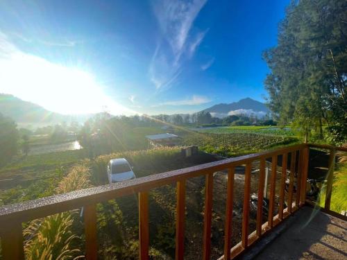 a balcony with a view of a field with a chair at The Iris Volcano in Kubupenlokan