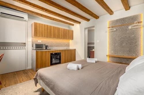 a bedroom with a large bed and a kitchen at Diocletian's Suites Centre Palace in Split
