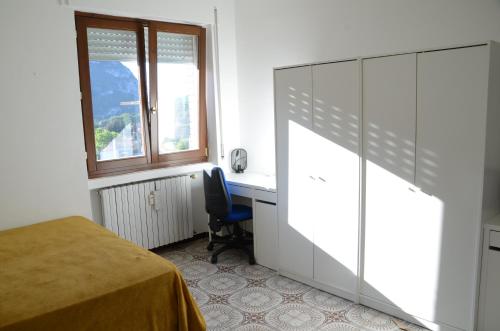 a bedroom with a bed and a desk and a window at Top Floor Apartment 5 minutes walk to lake in Malgrate
