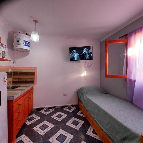 a small bedroom with a bed and a tv on the wall at MARRAKECH Apart-hotel in Camet Norte