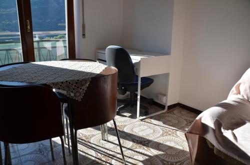 a table and chairs in a room with a window at Top Floor Apartment 5 minutes walk to lake in Malgrate