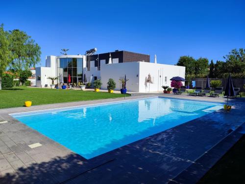 a swimming pool in front of a house at VILA FLAMINGO in Belmonte