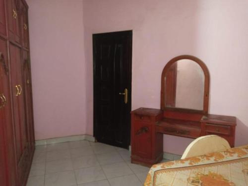 a bedroom with a dresser and a mirror and a bed at Egypt Pyramids Hotel in Cairo