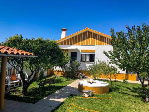 a house with a garden with a fountain in the yard at Ninho da Irene in Vieira de Leiria