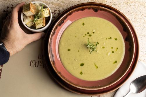 a person holding a bowl of soup on a table at Locanda Expanificio in Agrigento