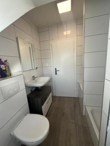 Un baño blanco con inodoro y lavabo. en Beishan Apartment Dachgeschoss, en Núremberg
