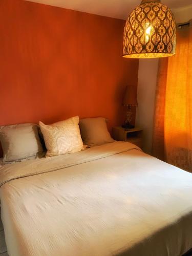 une chambre avec un lit et un lustre dans l'établissement Maison paisible avec jardin, terrasse privée, proche du lac de Sanguinet, à Sanguinet