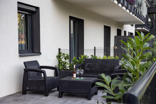 a patio with chairs and a table with wine glasses at Modern Nest in Zamość