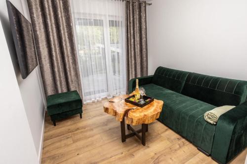 a living room with a green couch and a table at Modern Nest in Zamość