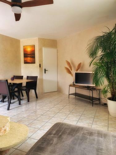 un salon avec une table avec un ordinateur portable dessus dans l'établissement Maison paisible avec jardin, terrasse privée, proche du lac de Sanguinet, à Sanguinet