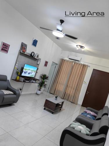 a living room with two couches and a tv at Win & Sha's Homestay in Miri